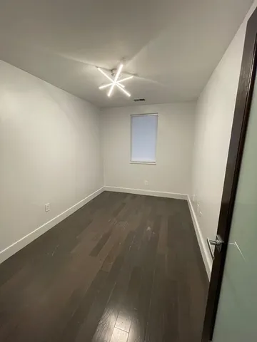 an empty room with a window and wooden floor