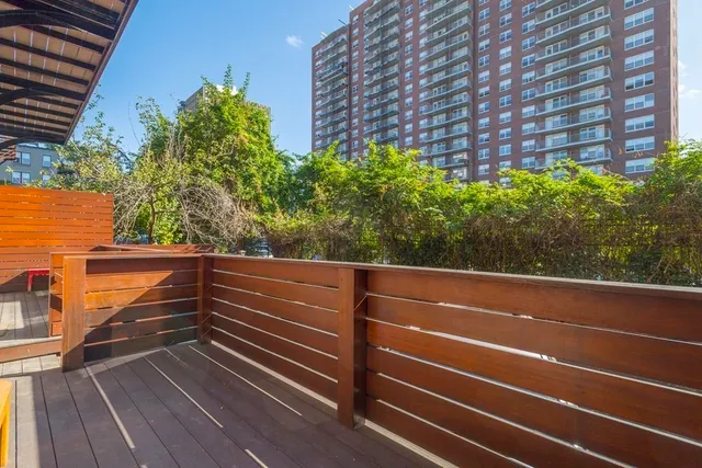 a view of deck with wooden floor and fence and a bench