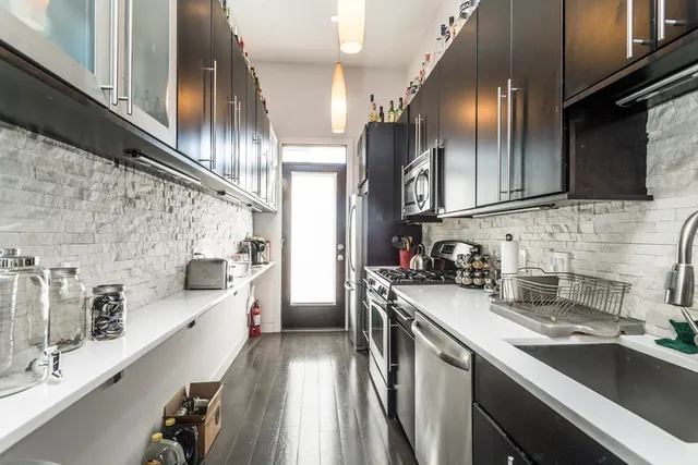 a kitchen with stainless steel appliances a sink a stove and cabinets
