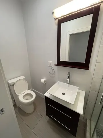 a bathroom with a toilet a sink and mirror
