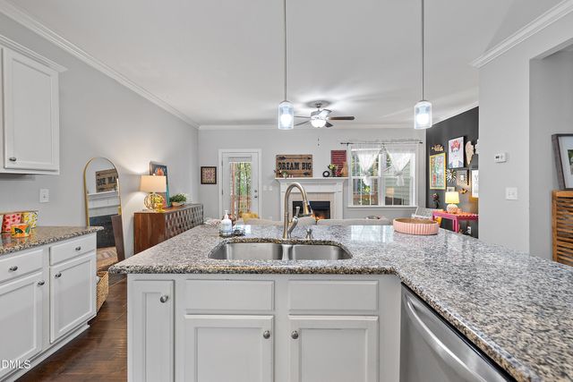 a kitchen with kitchen island granite countertop a sink a stove and cabinets