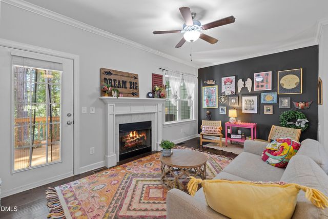 a living room with furniture kitchen view and a wooden floor