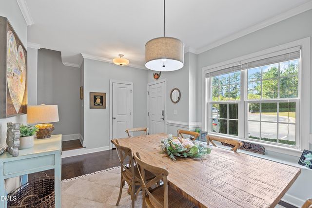 a living room with dining table and a large window