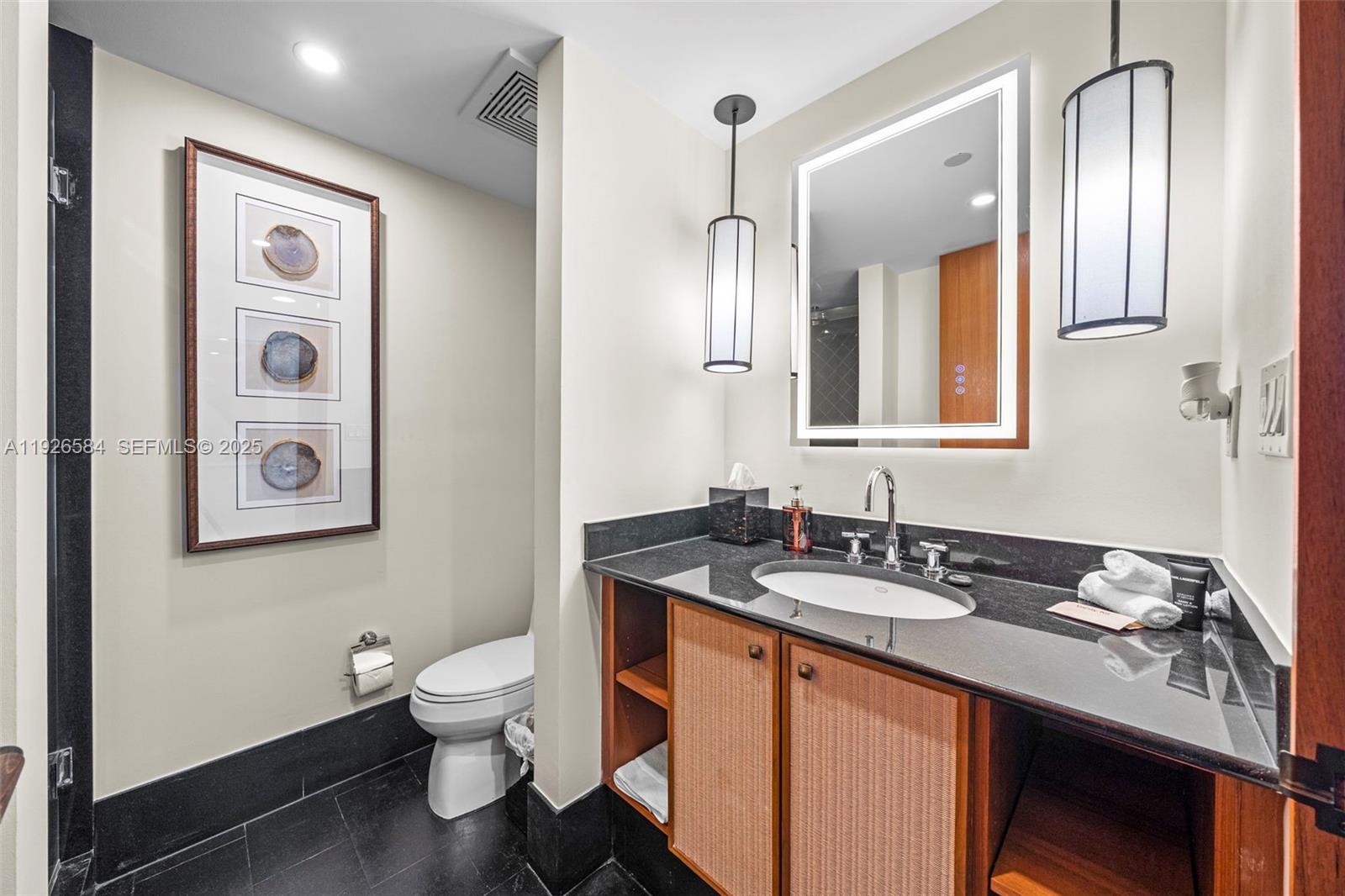 101 20th Street, Unit 3202 Miami Beach, FL 33139 - Photo 43 of 54 a bathroom with a sink a toilet and a mirror