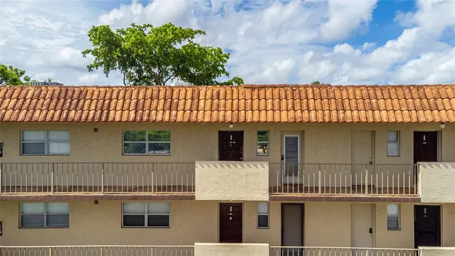 a front view of a building with cars parked