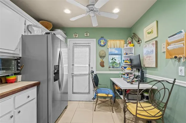 a kitchen with stainless steel appliances kitchen island granite countertop a refrigerator a sink a dining table and chairs with wooden floor