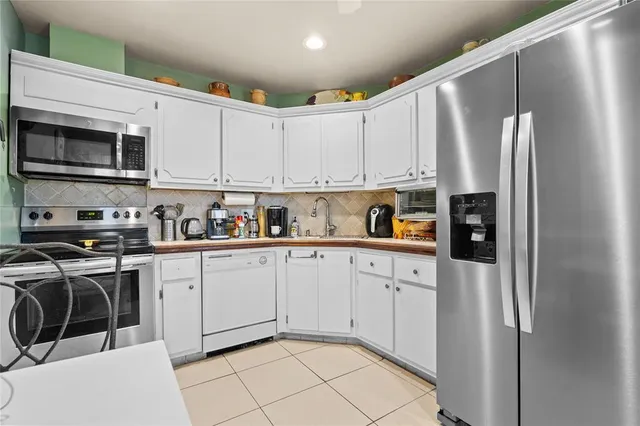 a kitchen with stainless steel appliances granite countertop a refrigerator sink and cabinets