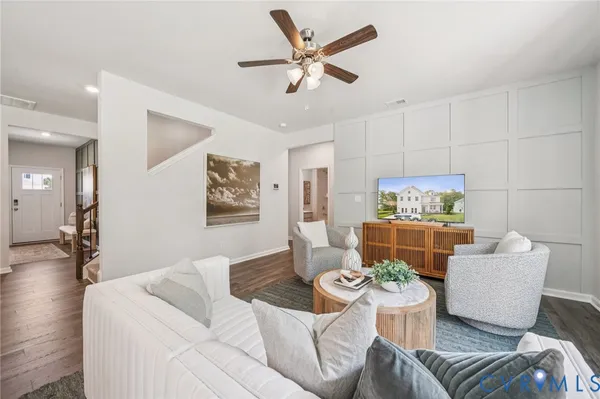 a living room with furniture and a wooden floor