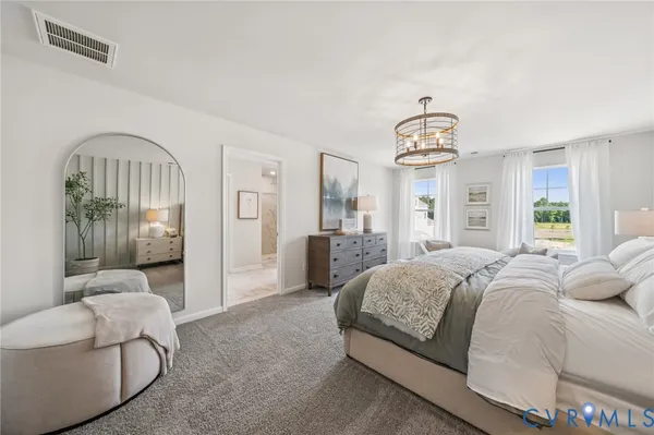 a spacious bedroom with a bed and a chandelier