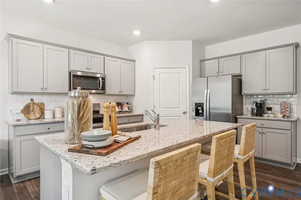 a kitchen with kitchen island granite countertop a sink stove and refrigerator