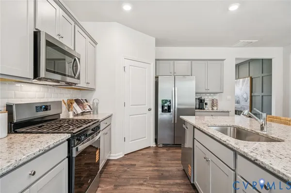 a kitchen with stainless steel appliances granite countertop a sink stove and refrigerator