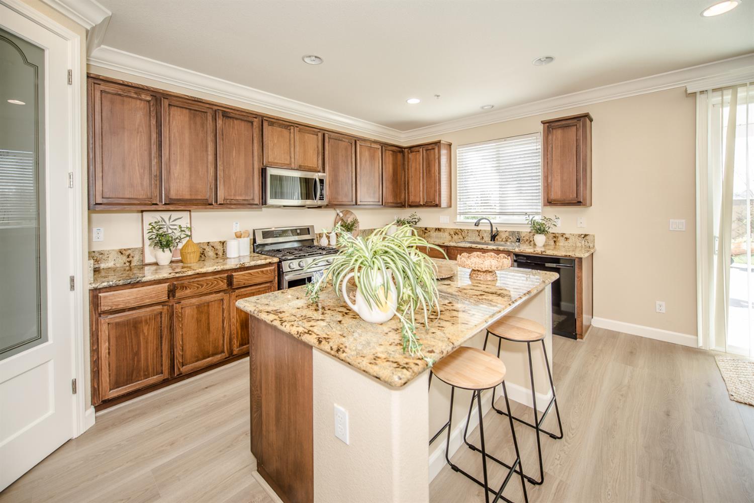 1701 Sandypoint Road West Sacramento, CA 95691 - Photo 10 of 41 a kitchen with stainless steel appliances granite countertop a stove a sink dishwasher a microwave oven and a dining table with wooden floor