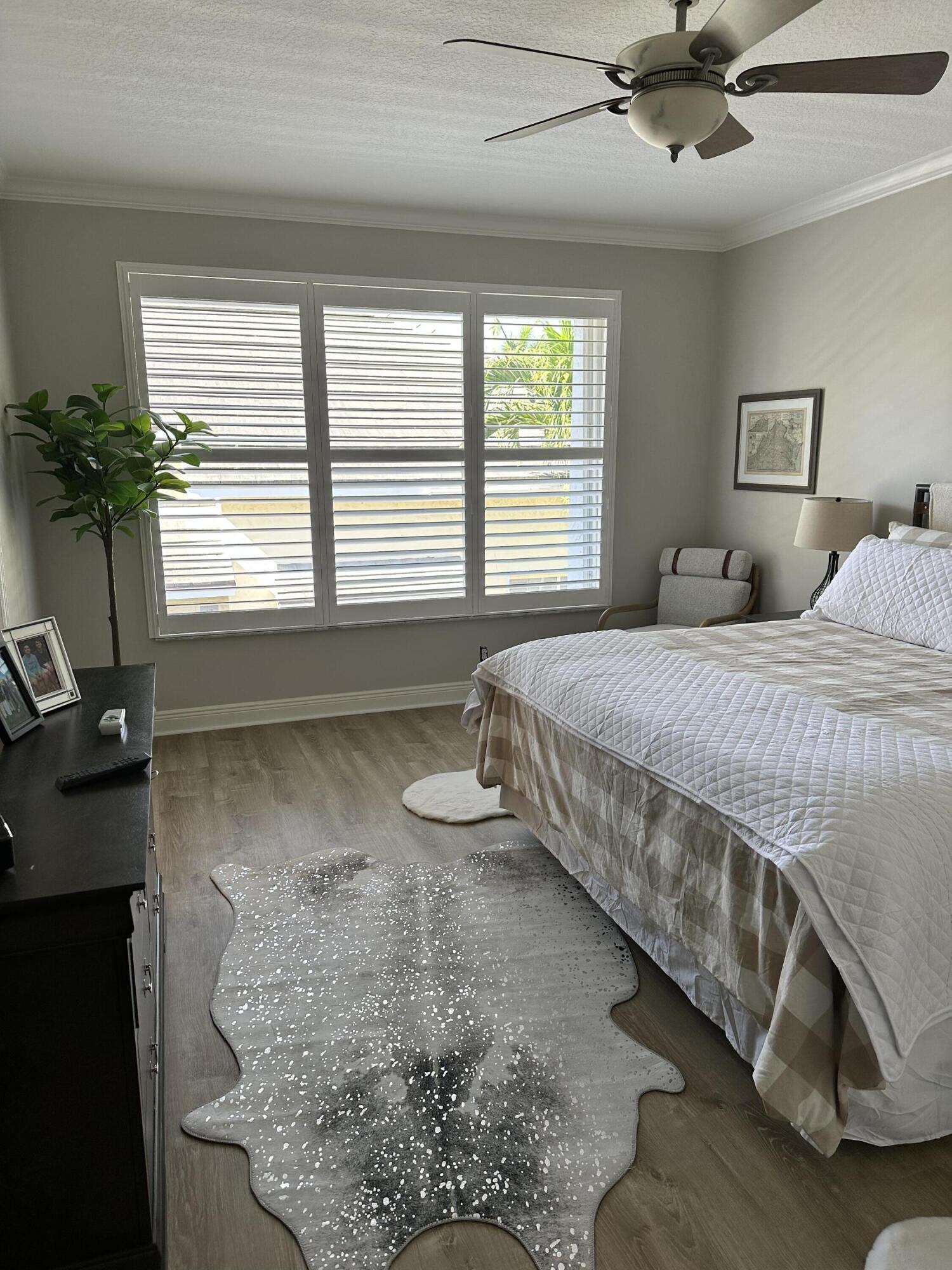 3028 Windward Way Jupiter, FL 33477 - Photo 12 of 48 a bedroom with a bed and a chandelier