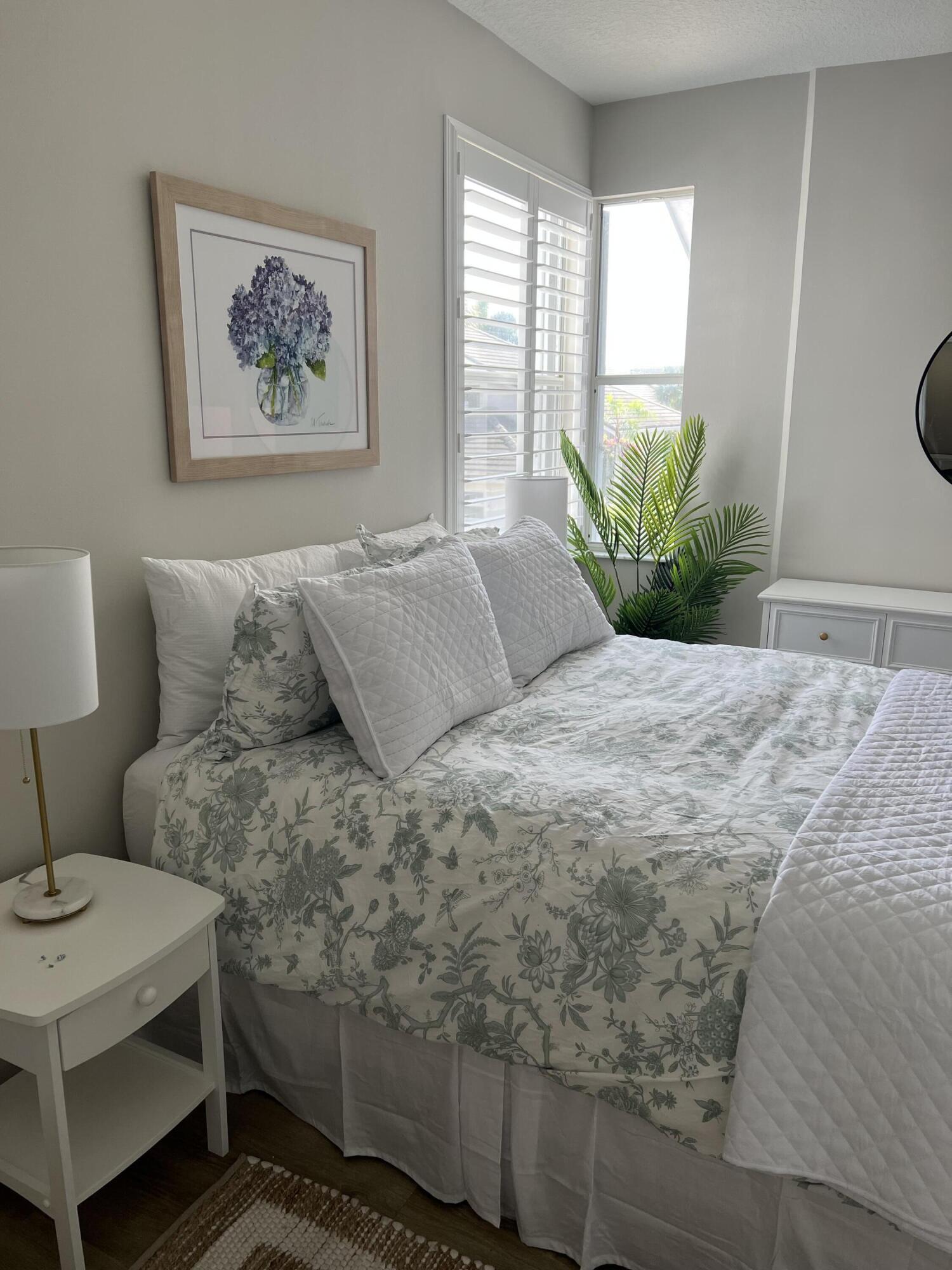3028 Windward Way Jupiter, FL 33477 - Photo 15 of 48 a bedroom with a bed a couch and potted plant on the dresser