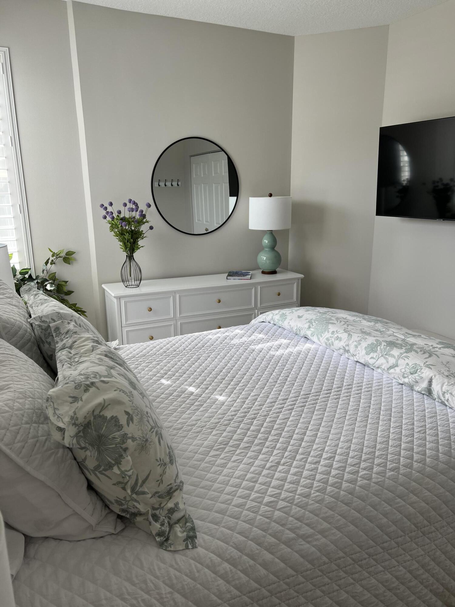 3028 Windward Way Jupiter, FL 33477 - Photo 17 of 48 a bedroom with a bed and a flat tv screen on the dresser