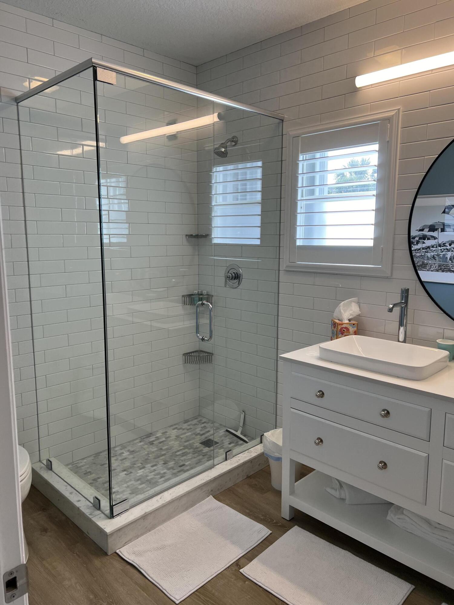 3028 Windward Way Jupiter, FL 33477 - Photo 20 of 48 a bathroom with a shower sink and mirror