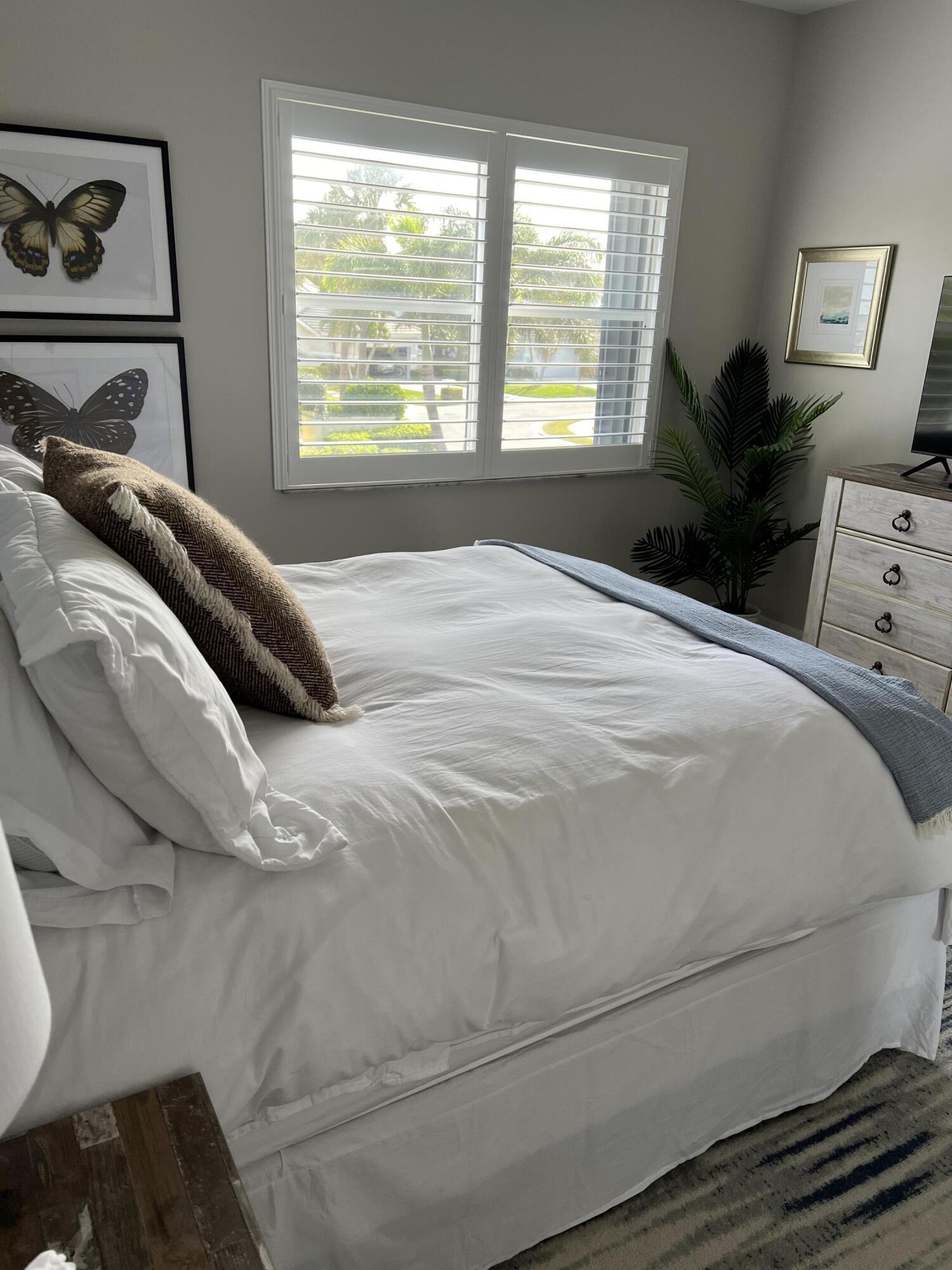 3028 Windward Way Jupiter, FL 33477 - Photo 25 of 48 a bedroom with a bed and wooden floor