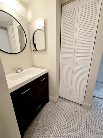 a bathroom with a sink a toilet a rug and a window