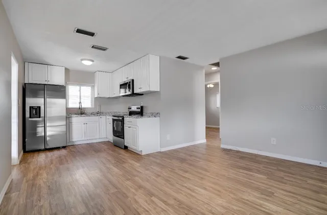 a kitchen with wooden floors and refrigerator