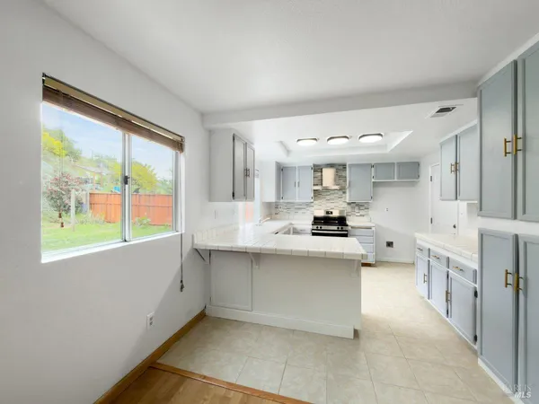 a large white kitchen with a large window