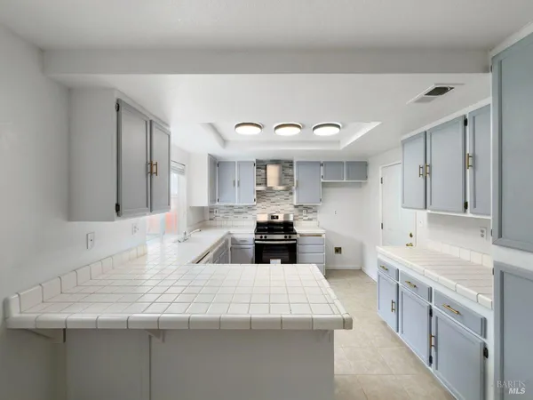 a large kitchen with kitchen island a sink stainless steel appliances and cabinets