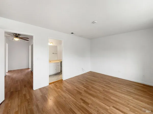 a view of empty room with wooden floor