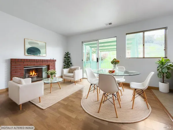 a living room with furniture a fireplace and a large window