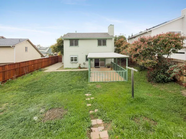 a view of house with a backyard