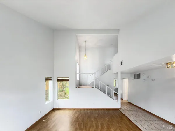 a view of a hallway with wooden floor and staircase