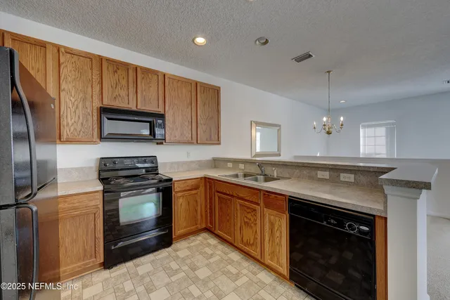 a kitchen with stainless steel appliances granite countertop a stove a sink dishwasher a refrigerator and a microwave