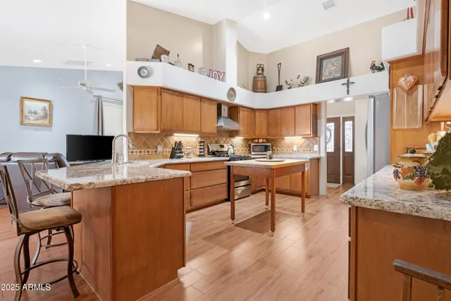 a kitchen with stainless steel appliances kitchen island granite countertop a sink and cabinets