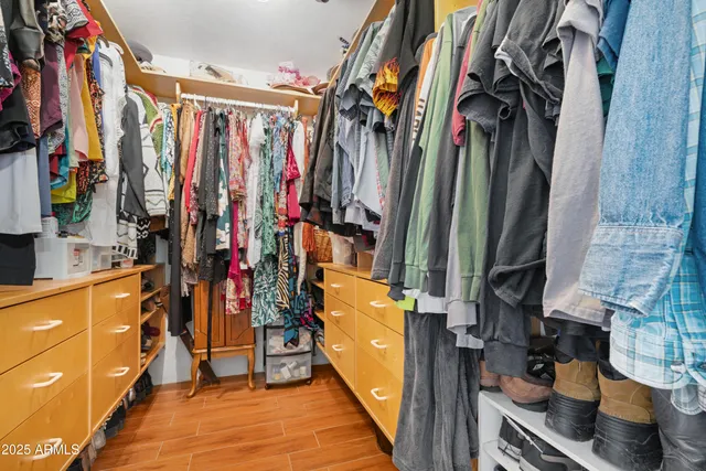 a view of walk in closet with clothes and shoes