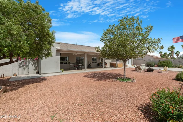 a view of a house with backyard and sitting area