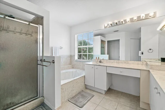 a bathroom with a tub sink shower and mirror