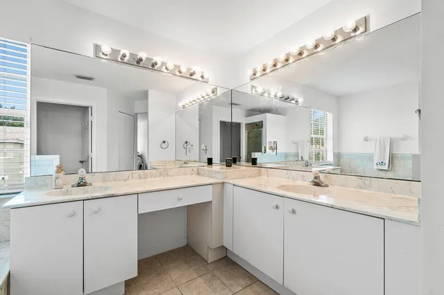 a large white bathroom with a sink and mirror