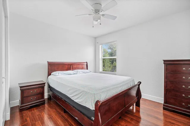 a bed sitting in a bedroom next to a window with wooden floor