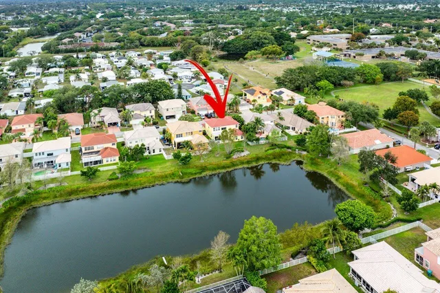 an aerial view of residential houses with outdoor space and lake view