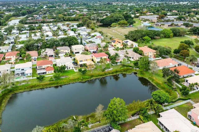 an aerial view of residential houses with outdoor space and lake view