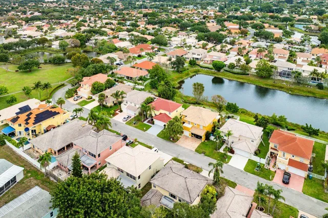 an aerial view of residential houses with outdoor space and lake view