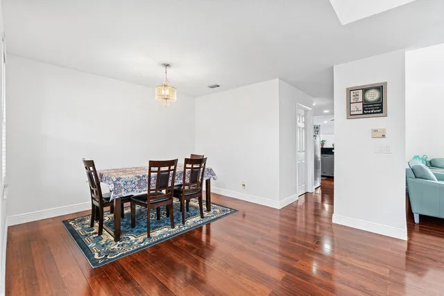 a dining room with furniture a chandelier and wooden floor