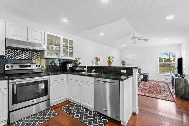 a kitchen with stainless steel appliances a stove sink and cabinets