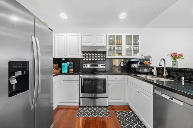 a kitchen with stainless steel appliances granite countertop a refrigerator sink and stove