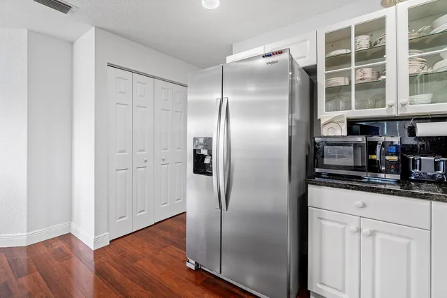 a kitchen with stainless steel appliances granite countertop a refrigerator and a sink