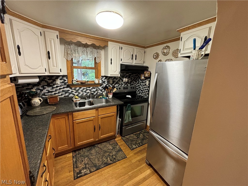 2417 Mc Adoo Ridge Road Wellsburg, WV 26070 - Photo 2 of 33 Kitchen featuring appliances with stainless steel finishes, sink, backsplash, ornamental molding, and light hardwood / wood-style flooring