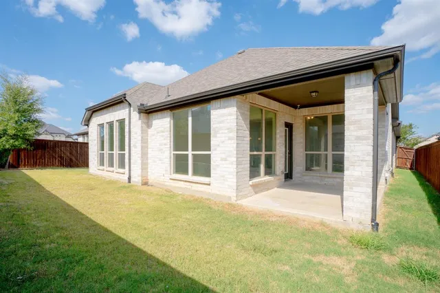 a view of a house with backyard and wooden fence