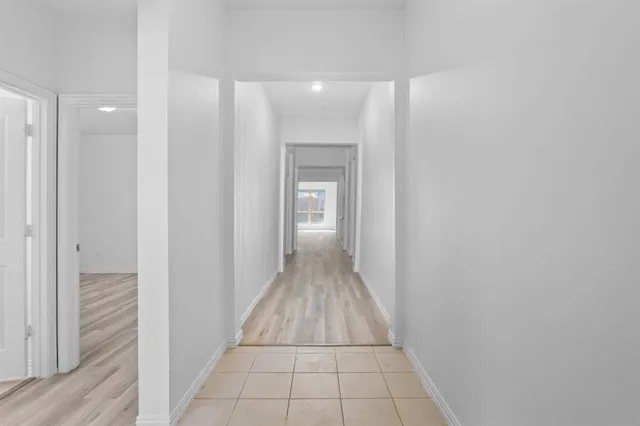 an empty room with wooden floor and window