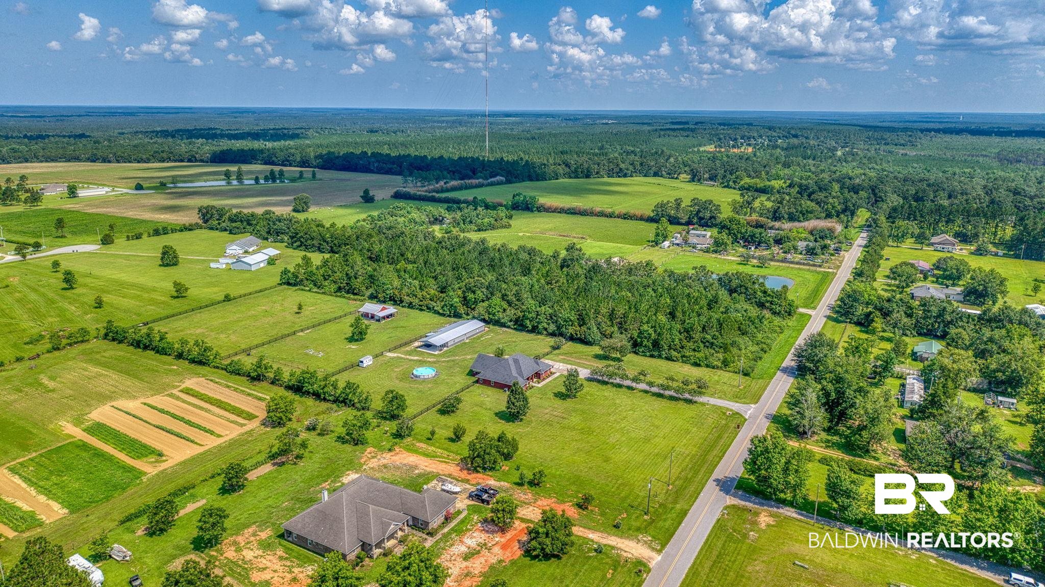 26895 C R Watson Road Robertsdale, AL 36567 - Photo 81 of 89 Expansive rural landscape featuring a paved road, scattered residential properties, mature trees, and agricultural fields