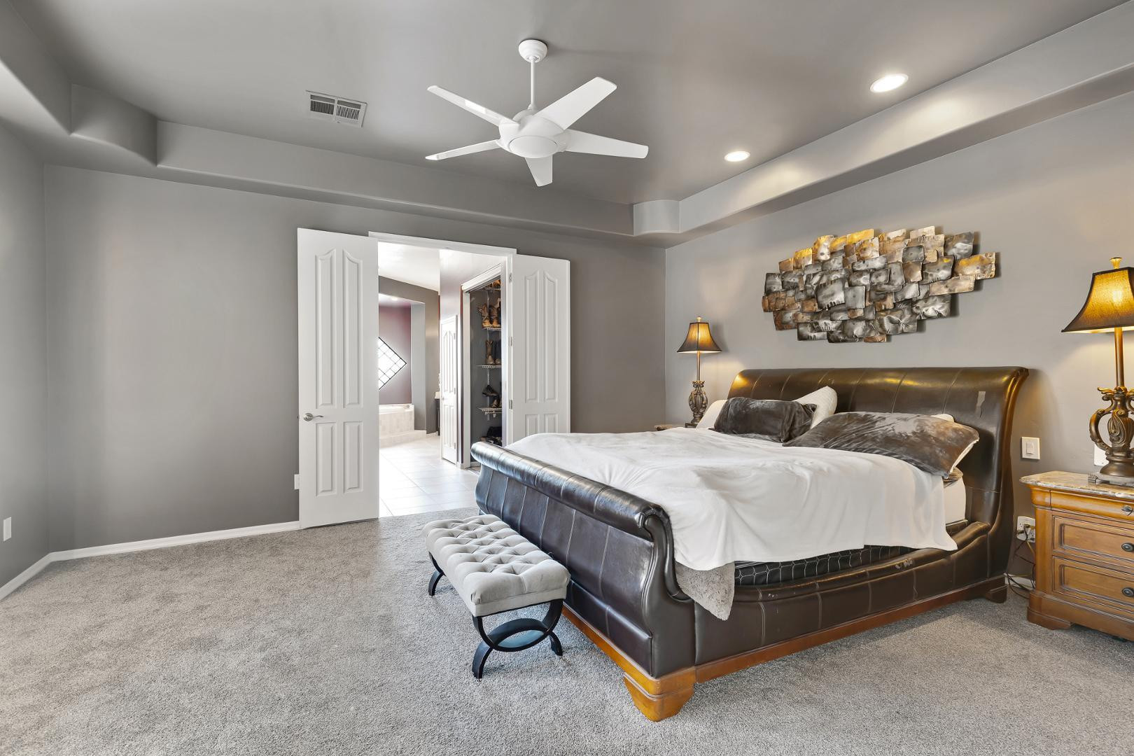 8540 East McDowell Road, Unit 10 Mesa, AZ 85207 - Photo 16 of 25 a spacious bedroom with a bed and a chandelier