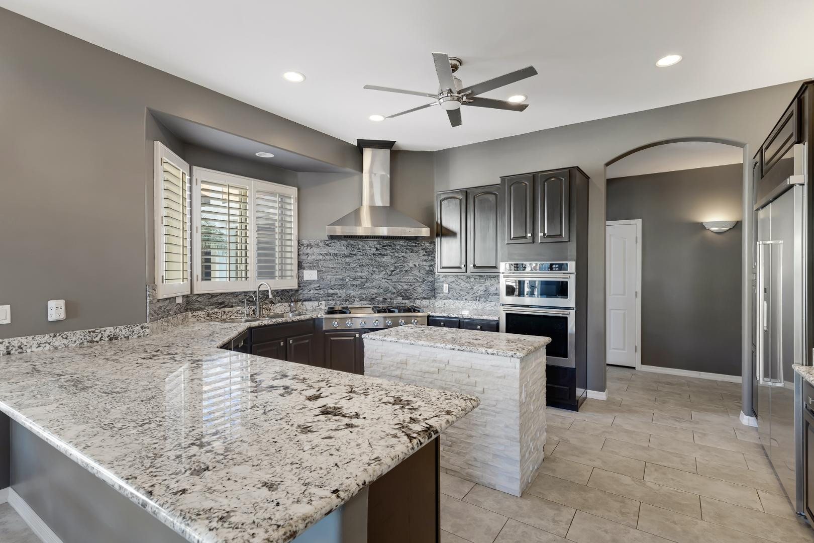 8540 East McDowell Road, Unit 10 Mesa, AZ 85207 - Photo 3 of 25 a kitchen with a sink a counter top stainless steel appliances and cabinets