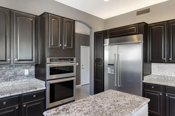 a kitchen with granite countertop stainless steel appliances and wooden cabinets